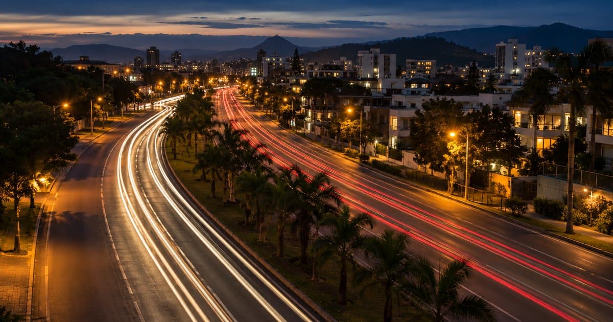Trilhas de luz vermelhas e brancas de carros numa avenida ao entardecer, o fluxo por trás de quanto custa anunciar no Google